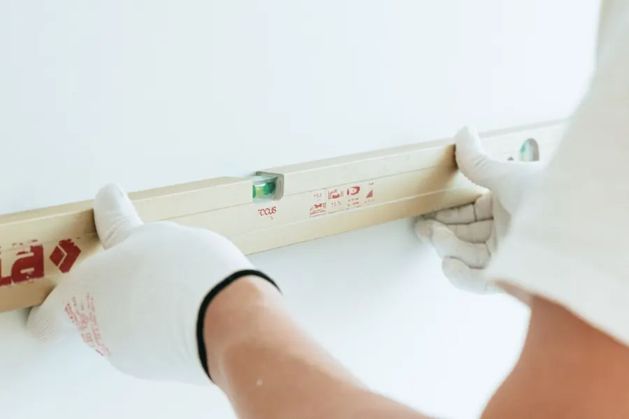 Waterpas tegen een wand tijdens onderhoudswerk